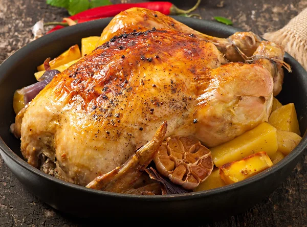 Pečené celé kuře s brambory, česnekem a cibulkou — Stock fotografie