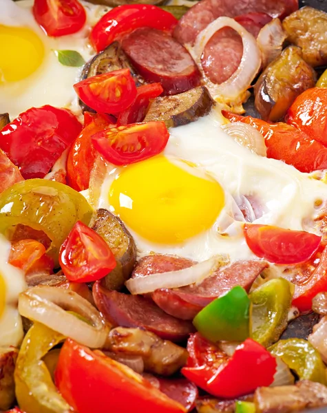 Fried eggs with fresh vegetables and sausage over white background — Stock Photo, Image