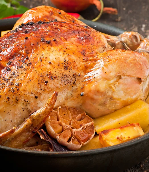 Pečené celé kuře s brambory, česnekem a cibulkou — Stock fotografie