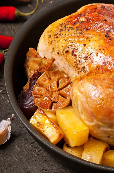 Baked whole chicken with potatoes, garlic and onion — Stock Photo, Image