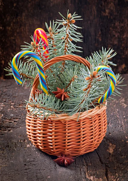 Decorações de Natal e ramos de abeto na cesta no velho fundo de madeira — Fotografia de Stock