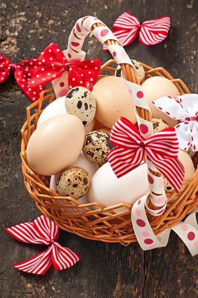 Easter eggs and basket on a wooden background — Stock Photo, Image