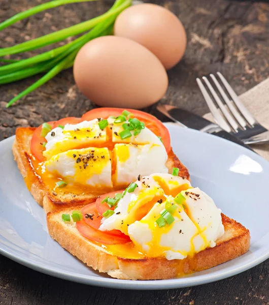 Huevos escalfados en tostadas con tomate y pimienta — Foto de Stock