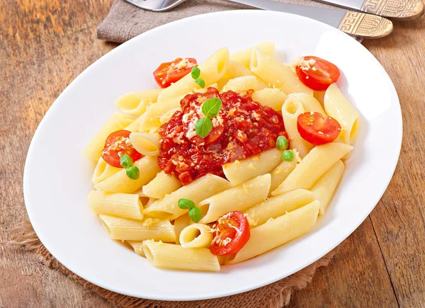 Bolognese sos, parmesan peyniri ve fesleğen ile Penne makarna — Stok fotoğraf