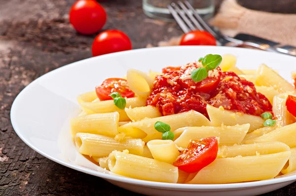 Bolognese sos, parmesan peyniri ve fesleğen ile Penne makarna — Stok fotoğraf