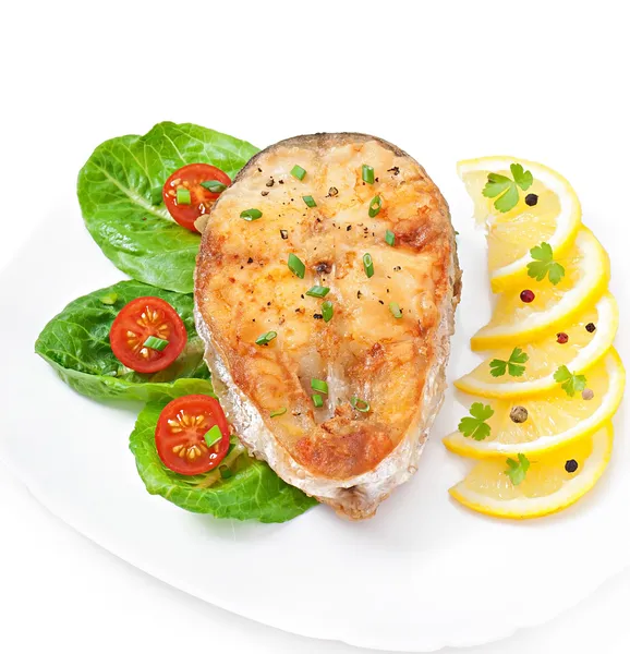 Рыбное блюдо - жареное филе рыбы с овощами на белом фоне — стоковое фото