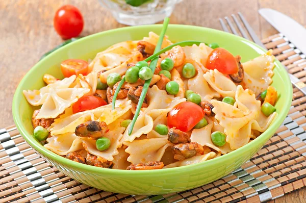 Farfalle pasta with seafood, cherry tomatoes and green peas — Stock Photo, Image