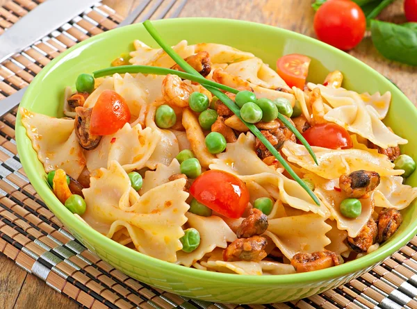 Farfalle pasta with seafood, cherry tomatoes and green peas — Stock Photo, Image