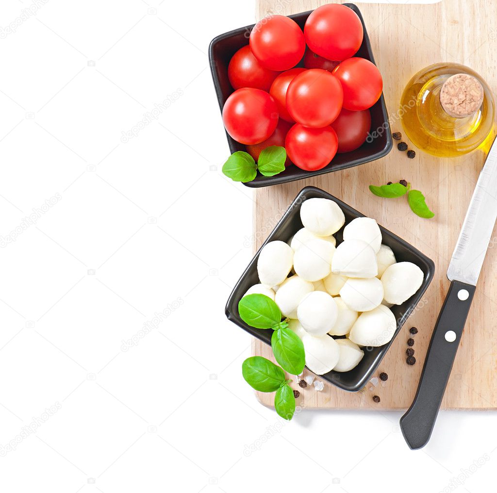 Mozzarella, tomatoes and fresh basil leaves on white background