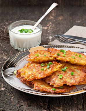 Fried potato pancakes on the old wooden background clipart