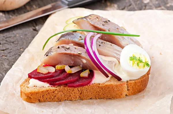 Sandwich de pan de centeno con arenque, remolacha, cebolla y huevo —  Fotos de Stock