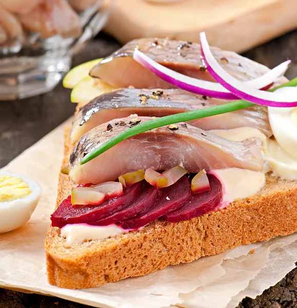 Szendvics, rozs kenyér, a hering, a céklát, a hagymát és a tojás — Stock Fotó