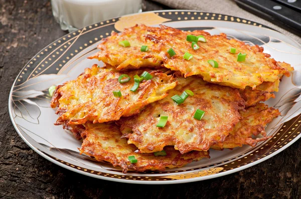 Gebakken Aardappelpannenkoekjes op de oude houten achtergrond — Stockfoto