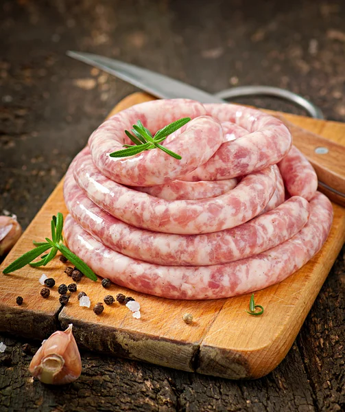 Salsiccia fresca cruda sul vecchio sfondo di legno — Foto Stock