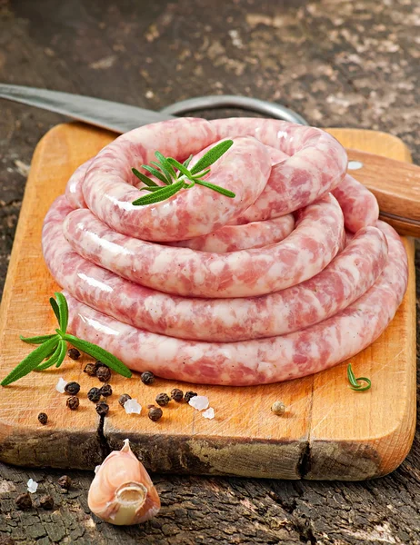 Fresh raw sausage on the old wooden background — Stock Photo, Image