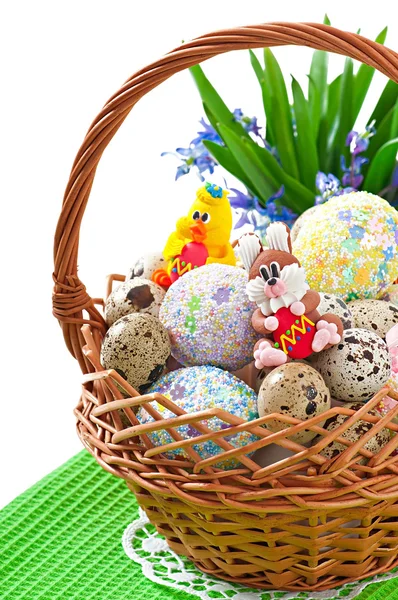 Huevos de Pascua coloridos en una cesta sobre un fondo blanco —  Fotos de Stock