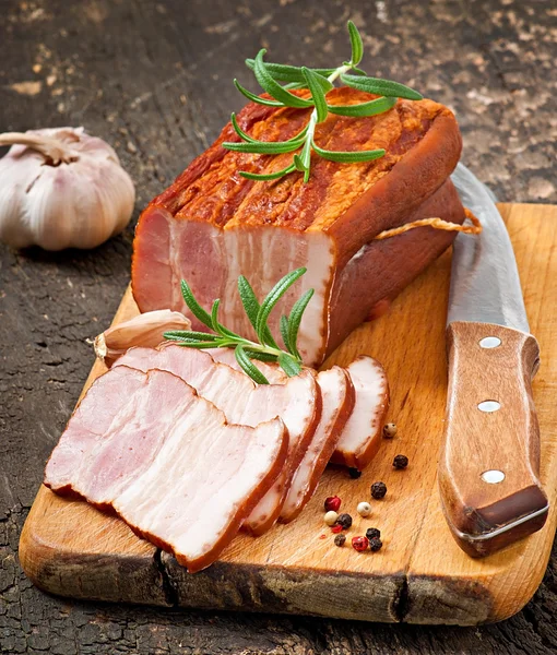 Slices smoked bacon on the old wooden background — Stock Photo, Image