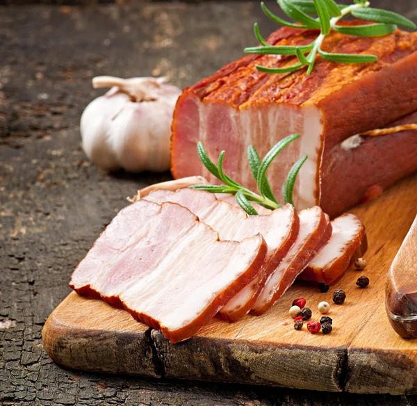 Rebanadas de tocino ahumado sobre el fondo de madera viejo — Foto de Stock