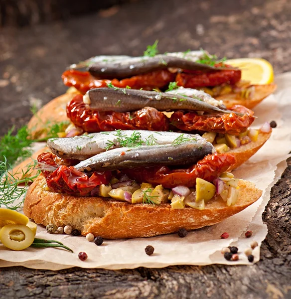 Crostini com anchovas, azeitonas e tomates secos ao sol — Fotografia de Stock