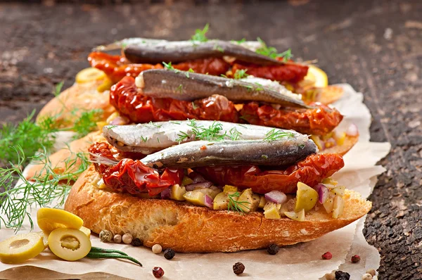 Crostini hamsi, zeytin ve kurutulmuş domates ile — Stok fotoğraf