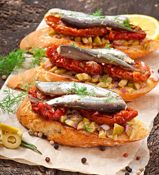 Crostini com anchovas, azeitonas e tomates secos ao sol — Fotografia de Stock