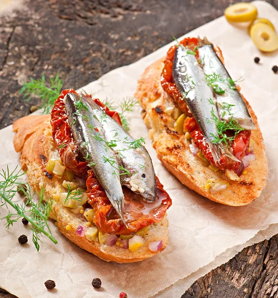 Crostini with anchovies, olives and sun-dried tomatoes — Stock Photo, Image
