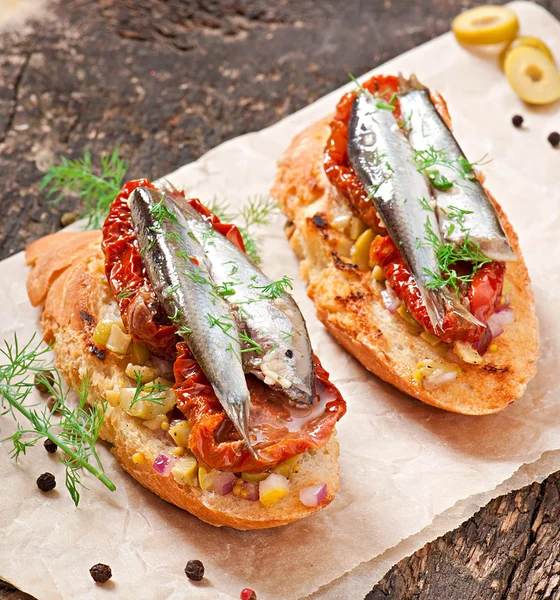 Crostini com anchovas, azeitonas e tomates secos ao sol — Fotografia de Stock