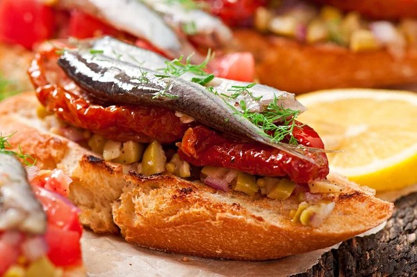 Crostini con anchoas, aceitunas y tomates secados al sol — Foto de Stock