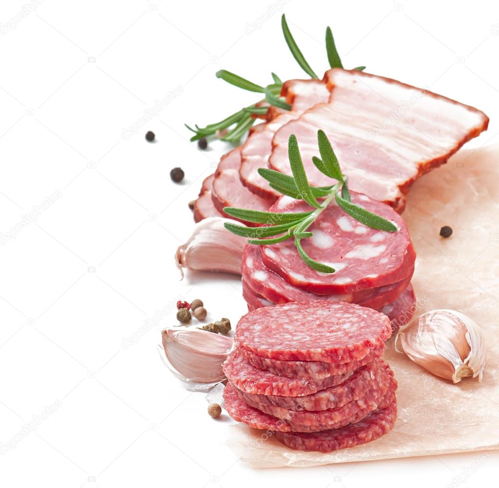 Assorted deli meats, rosemary and pepper, isolated on white