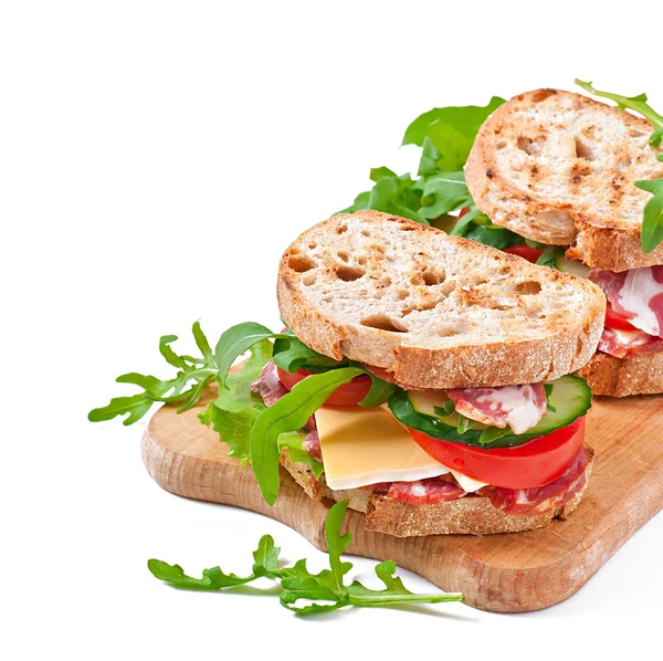 Panino con prosciutto, formaggio e verdure fresche su sfondo bianco — Foto Stock