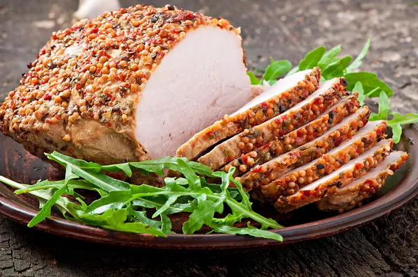 Gebakken varkensvlees met rucola bladeren — Stockfoto