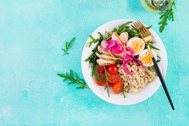 Taze salata. Yulaf ezmeli kahvaltı kasesi, tavuk fileto, domates, kırmızı soğan ve haşlanmış yumurta. Sağlıklı yiyecekler. Vejetaryen Buda kasesi. Üst manzara, düz uzanma