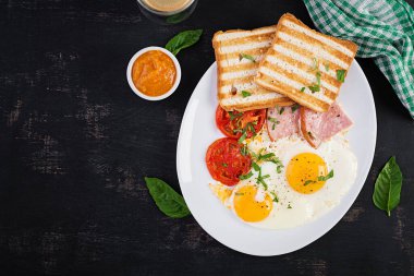 Jambonlu yumurta, domates ve tost. Lezzetli İngiliz Kahvaltısı. Brunch olsun. Üst görünüm, genel görünüm