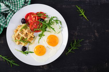 Kabaklı kahvaltı, kızarmış yumurta, domates, siyah zeytin ve beyaz arka planda roka. Aperatifler, aperatifler, brunch. Sağlıklı vejetaryen yemekleri. Üst görünüm, genel görünüm, kopyalama alanı