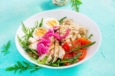 Taze salata. Yulaf ezmeli kahvaltı kasesi, tavuk fileto, domates, kırmızı soğan ve haşlanmış yumurta. Sağlıklı yiyecekler. Vejetaryen Buda kasesi..