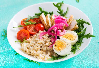 Taze salata. Yulaf ezmeli kahvaltı kasesi, tavuk fileto, domates, kırmızı soğan ve haşlanmış yumurta. Sağlıklı yiyecekler. Vejetaryen Buda kasesi..