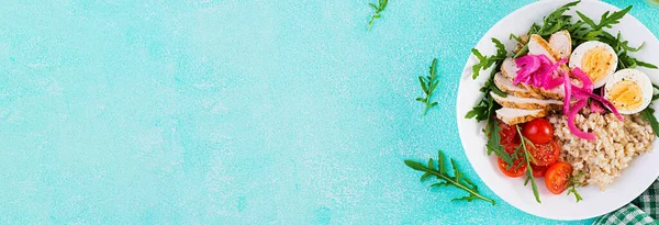 Taze salata. Yulaf ezmeli kahvaltı kasesi, tavuk fileto, domates, kırmızı soğan ve haşlanmış yumurta. Sağlıklı yiyecekler. Vejetaryen Buda kasesi. Üst görünüm, afiş