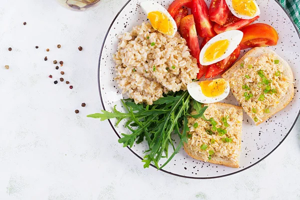 Taze salata. Yulaf ezmeli kahvaltı kasesi tavuklu sandviç, domates ve haşlanmış yumurta. Sağlıklı yiyecekler. Üst manzara, düz uzanma