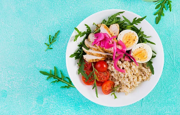 Taze salata. Yulaf ezmeli kahvaltı kasesi, tavuk fileto, domates, kırmızı soğan ve haşlanmış yumurta. Sağlıklı yiyecekler. Vejetaryen Buda kasesi. Üst manzara, düz uzanma