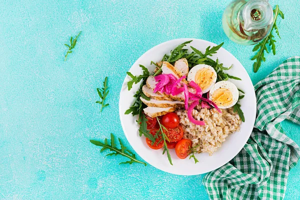 Taze salata. Yulaf ezmeli kahvaltı kasesi, tavuk fileto, domates, kırmızı soğan ve haşlanmış yumurta. Sağlıklı yiyecekler. Vejetaryen Buda kasesi. Üst manzara, düz uzanma