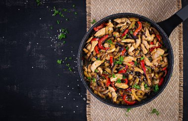 Kızartmayı tavuk, patlıcan, kabak ve tatlı biberle karıştırın. Çin yemeği. Üst görünüm, yukarıda