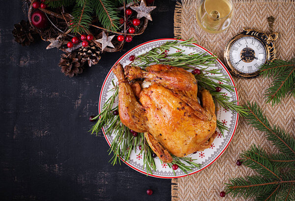 Baked  chicken or turkey. The Christmas table is served with turkey, decorated with bright tinsel. Fried chicken, table. Christmas dinner. Table setting. Top view, above