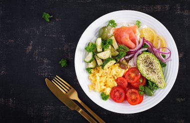 Domatesli tuzlu somon salatası, salatalık, çırpılmış yumurta ve avokado. Ketogenik diyet kahvaltısı. Keto öğle yemeği. Üst görünüm, genel görünüm