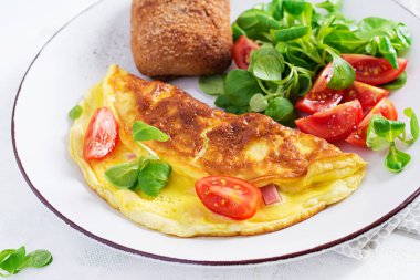 Domatesli omlet, jambon, peynir ve tabakta mısır salatası. Frittata - İtalyan omleti.