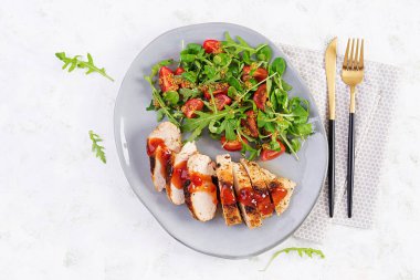 Kızarmış tavuk fileto salata, taze domates ve roka. Üst manzara, düz uzanma