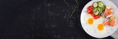 Diyet kahvaltı. Yağda yumurta ve sandviç, tuzlu somon ve taze salata. Üst görünüm, afiş