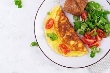 Domatesli omlet, jambon, peynir ve tabakta mısır salatası. Frittata - İtalyan omleti. Üst görünüm, genel görünüm