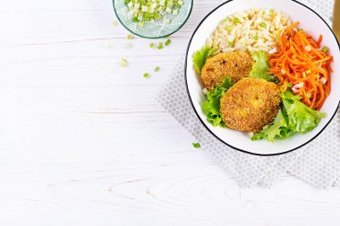 Orzo pasta, carrots and chicken burgers in white bowl. Risoni pasta. Lunch. Top view, above, copy space