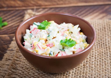 Tahta masada mısır ve yengeç dilimli salata. Geleneksel Rus mutfağı.