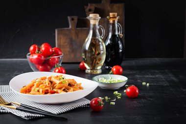 Classic italian pasta penne marinara with mussels and green onions on dark table. Penne pasta with sauce marinara.